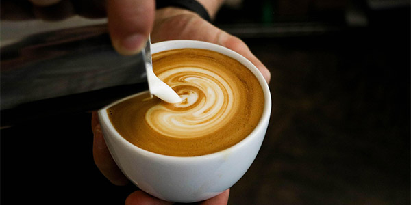 コーヒーカップにミルクを注いでいる姿